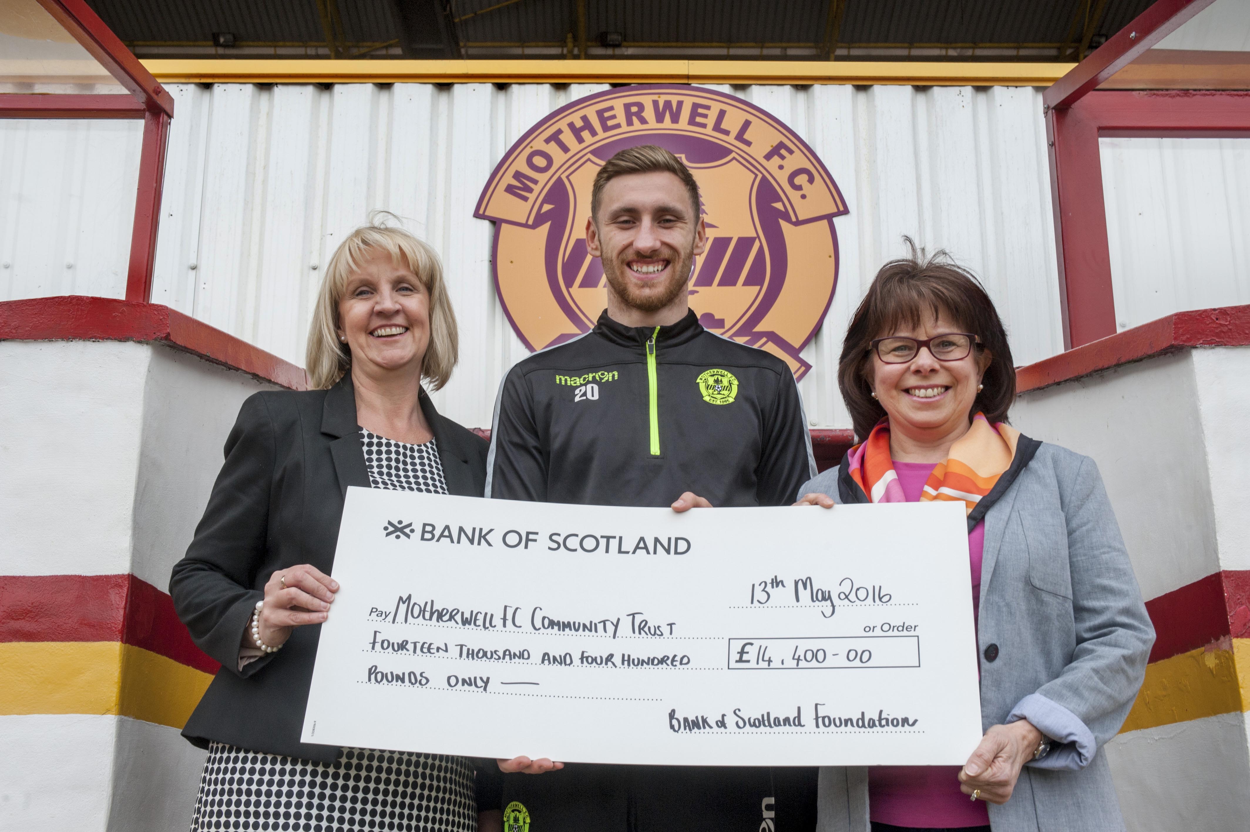 3 people holding an oversized check