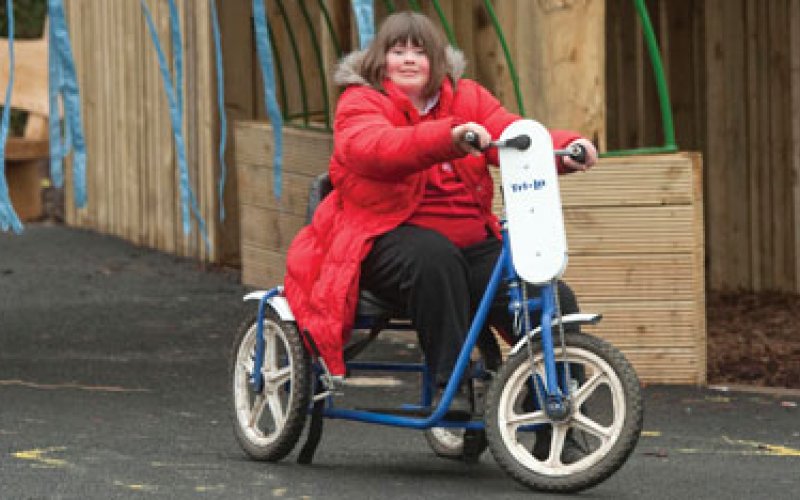 Girl on a hand pedalled tricycle